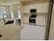 Bright kitchen featuring white cabinets, stainless steel appliances, and tile flooring at 10580 Riva Grande Ct, Las Vegas, NV 89135