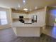 Well-lit kitchen features stainless steel appliances, white cabinetry and an eat in bar at 10580 Riva Grande Ct, Las Vegas, NV 89135