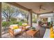 Covered patio with comfortable seating, ceiling fan, and a view of the landscaped yard at 10580 Riva Grande Ct, Las Vegas, NV 89135