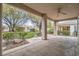 Covered patio offers views of landscaped backyard with mature trees and manicured lawn at 10580 Riva Grande Ct, Las Vegas, NV 89135