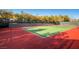 An outdoor tennis court surrounded by trees and fencing, with a green playing surface at 10580 Riva Grande Ct, Las Vegas, NV 89135