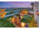 Aerial backyard view featuring a putting green, garden area, and city lights at twilight at 11680 Evergreen Creek Ln, Las Vegas, NV 89135