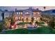 An expansive backyard featuring manicured lawn, a fire pit, water feature, and seamless access to the home's elegant living spaces at 11680 Evergreen Creek Ln, Las Vegas, NV 89135