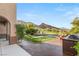 Scenic backyard with a built-in grill, comfortable seating, lush landscaping, and mountain views at 11680 Evergreen Creek Ln, Las Vegas, NV 89135