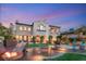 Backyard featuring outdoor entertaining space, lush greenery, fire pit and inviting ambiance at twilight at 11680 Evergreen Creek Ln, Las Vegas, NV 89135