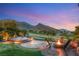 Scenic backyard with a cozy fire pit and elegant outdoor seating area, surrounded by lush landscaping at 11680 Evergreen Creek Ln, Las Vegas, NV 89135
