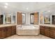 Luxurious bathroom with a soaking tub, dual vanities, and mirrored walls offering a bright and open feel at 11680 Evergreen Creek Ln, Las Vegas, NV 89135