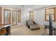 Comfortable bedroom with plush seating, an entertainment center, and natural light from windows with custom shutters at 11680 Evergreen Creek Ln, Las Vegas, NV 89135