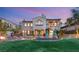 Two-story home with landscaped yard and outdoor water feature and lighting at twilight at 11680 Evergreen Creek Ln, Las Vegas, NV 89135