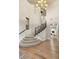 Grand foyer featuring a stunning chandelier, staircase with dark wood railing, and hardwood flooring at 11680 Evergreen Creek Ln, Las Vegas, NV 89135