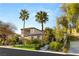 Beautiful two-story house with palm trees, lush greenery, and a well-maintained lawn at 11680 Evergreen Creek Ln, Las Vegas, NV 89135