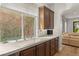 Kitchen counter and sink are illuminated by a large window, hardwood floor, and bright light at 11680 Evergreen Creek Ln, Las Vegas, NV 89135