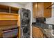 Convenient laundry room with stacked washer/dryer, custom cabinets, and granite countertops at 11680 Evergreen Creek Ln, Las Vegas, NV 89135