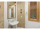 Stylish powder room with unique wall texture, decorative mirror, and a pedestal sink at 11680 Evergreen Creek Ln, Las Vegas, NV 89135