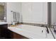 Bright bathroom with soaker tub, white shutters, decorative tile, and neutral-toned walls at 11834 Albissola Ave, Las Vegas, NV 89138