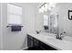 Spacious bathroom with dual sinks, black hardware, white countertops and large mirrors at 11834 Albissola Ave, Las Vegas, NV 89138