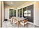 Covered patio boasts tile flooring, a wood table with chairs, and sliding glass doors at 11834 Albissola Ave, Las Vegas, NV 89138