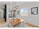 Dining room with light colored chairs, wood table, modern light fixture, and outdoor access at 11834 Albissola Ave, Las Vegas, NV 89138