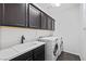 Convenient laundry room features matching washer and dryer with overhead cabinets at 11834 Albissola Ave, Las Vegas, NV 89138