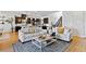 Open-concept living room with hardwood floors, neutral sofas, and adjacent kitchen at 11834 Albissola Ave, Las Vegas, NV 89138