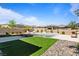 Lush artificial grass and mature landscaping surround this stunning backyard pool at 11834 Albissola Ave, Las Vegas, NV 89138