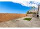 View of the backyard showing artificial turf, a concrete patio, and the exterior privacy wall at 140 Rolling Cove Ave, Henderson, NV 89011