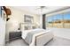 Stylishly staged bedroom with neutral tones and a large window showcasing exterior views at 1452 Melodic Lark Ln, Las Vegas, NV 89138