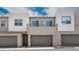 Modern townhome featuring clean architectural lines, gray garage doors and a second-story balcony at 1452 Melodic Lark Ln, Las Vegas, NV 89138