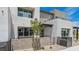 Contemporary stucco townhome with gated entry and a small tree in the front yard at 1452 Melodic Lark Ln, Las Vegas, NV 89138
