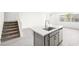Kitchen island with sink, gray cabinets, and nearby staircase at 1452 Melodic Lark Ln, Las Vegas, NV 89138