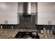 Modern kitchen with granite countertops, gray backsplash, stainless hood, and stainless steel appliances at 1608 Rock Ridge Pl, North Las Vegas, NV 89084