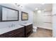 Bathroom featuring double sinks, dark wood cabinets, mirrors, and a walk-in shower at 1700 Ivanhoe Way, Las Vegas, NV 89102