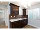 This kitchenette features sleek brown cabinets and a stylish backsplash beneath modern lighting at 1700 Ivanhoe Way, Las Vegas, NV 89102