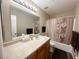 Neutral bathroom features a tub-shower, framed mirror and sink with wood cabinets at 2072 Mesquite Ln # 102, Laughlin, NV 89029