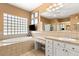 Large bathroom with a soaking tub, tiled surround, and vanity with dual sinks and lighting at 215 Great Gable Dr, Las Vegas, NV 89183
