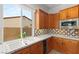 Classic kitchen features a double sink under a window, wood cabinets, and a decorative tile backsplash at 215 Great Gable Dr, Las Vegas, NV 89183