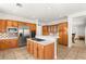 Bright kitchen boasts stainless steel appliances, wood cabinetry, and an island cooktop with bar seating at 215 Great Gable Dr, Las Vegas, NV 89183