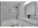 A modern bathroom with a shower-tub combo, white cabinets, and a square black shower head at 241 E Van Wagenen St, Henderson, NV 89015