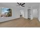 Bright bedroom with wood-look floors, ceiling fan, sunny window, and stairs just outside at 241 E Van Wagenen St, Henderson, NV 89015
