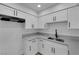 Updated kitchen featuring white cabinets, sleek countertops, stainless steel sink, and ample storage space at 241 E Van Wagenen St, Henderson, NV 89015