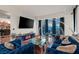 Modern living room with a large TV, blue sofa, hardwood floors, and cityscape views at 2700 Las Vegas Blvd # 1401, Las Vegas, NV 89109