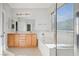 Bathroom featuring a double vanity, soaking tub, and glass enclosed shower at 2839 Strathallan Ave, Henderson, NV 89044