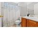 Cozy bathroom featuring a toilet, wooden vanity, white countertop, and shower with decorative curtain at 3023 Sunrise Bay Ave, North Las Vegas, NV 89031