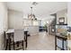 Bright dining area with tile floors, modern light fixture, and views into the living room at 3023 Sunrise Bay Ave, North Las Vegas, NV 89031
