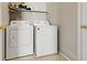 A bright laundry room features a washer and dryer, with shelf for storage and neutral wall color at 3023 Sunrise Bay Ave, North Las Vegas, NV 89031