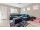 Bright living room with comfortable blue sectional, plush rug, and ample natural light at 3023 Sunrise Bay Ave, North Las Vegas, NV 89031