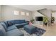 Inviting living room features a comfortable blue sectional, plush rug, and ample natural light at 3023 Sunrise Bay Ave, North Las Vegas, NV 89031