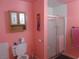 Bathroom with a shower, vanity, and toilet featuring pink walls and a decorative cabinet at 3127 Aloha Ave, Las Vegas, NV 89121