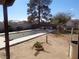 Backyard with an in-ground pool, patio area, mature trees, and desert landscaping under a sunny sky at 3127 Aloha Ave, Las Vegas, NV 89121