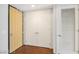 Bright hallway with hardwood floors with a closet and a light-colored wooden door at the end at 353 E Bonneville Ave # 375, Las Vegas, NV 89101